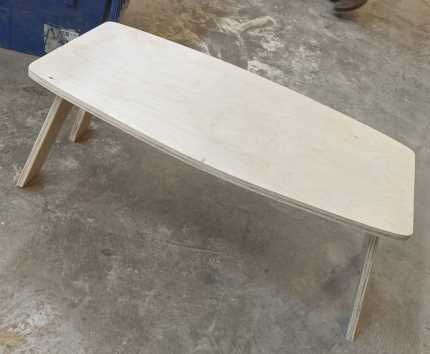 pale wooden folding coffee table in a workshop
