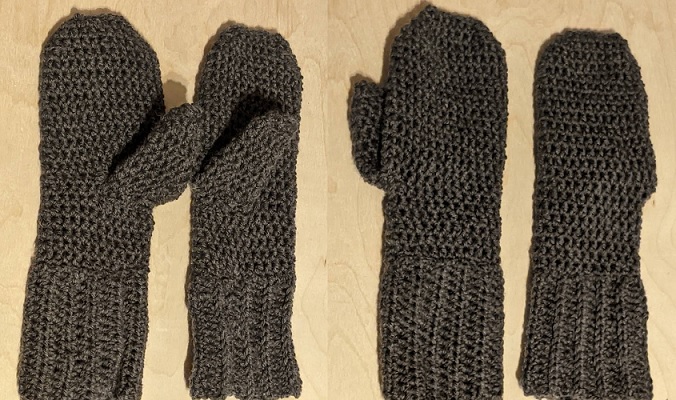 grey crocheted mittens on a wooden background