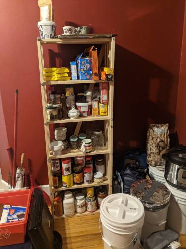 pale wooden shelf with food items on it in a room with red walls